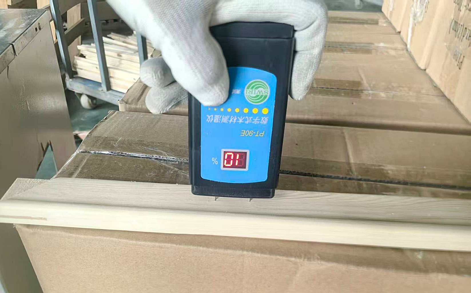 Moisture content testing of a finished pine wooden stretcher bar during quality inspection