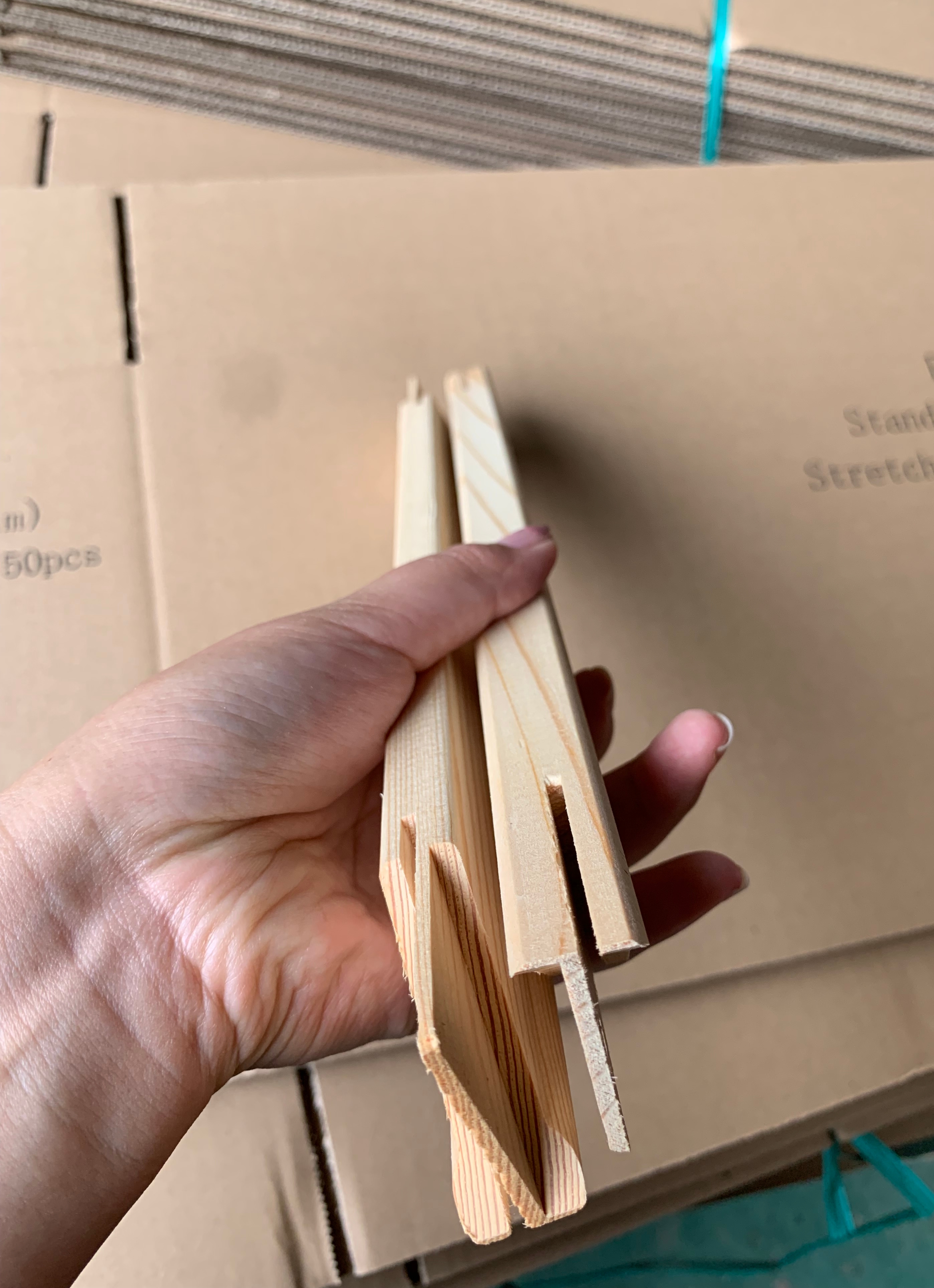 Long pine wooden stretcher bar showing its machined profile in factory production